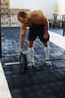 © Artem Varnitsin - Shot of male bodybuilder adding weights to barbell, standing in sport club