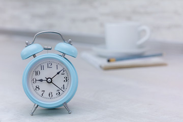 Wall Mural - Blue alarm clock in morning light and cup of coffee, copy space