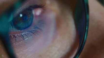Full HD. Woman eye looking surfing Internet, monitor reflection in glasses
