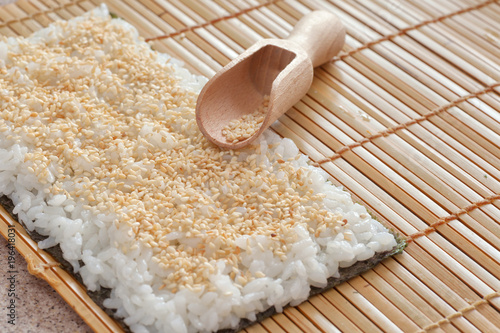 Sushi Preparation Nori With Rice And Sesame Seeds On Bamboo Mat
