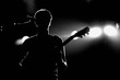 Silhouette of an unrecognizable man playing an electric guitar