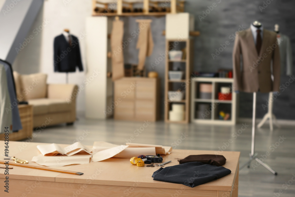 Tailoring tools and fabric on table in atelier