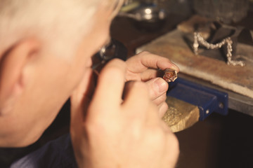 Wall Mural - Jeweler examining piece of gold, closeup