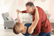 © Africa Studio - Happy mature couple dancing at home