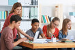 © Africa Studio - Group of teenagers doing homework with teacher in classroom