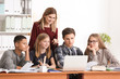 © Africa Studio - Group of teenagers doing homework with teacher in classroom