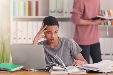 Canvas Print - African American teenage boy doing homework at table