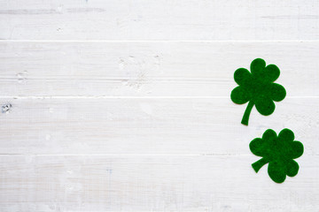 Wall Mural - Happy St Patricks Day message on green paper clover and white wooden background