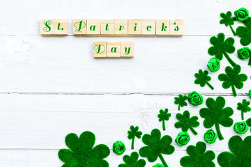 Wall Mural - Happy St Patricks Day message and a lot of green paper clover leaf on white wooden background