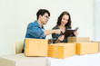 © anon - Worker In Warehouse Checking Box Using Digital Tablet.Start up small business entrepreneur SME or freelance man and woman working  at home concept, Young Asian small business owner, online marketing.