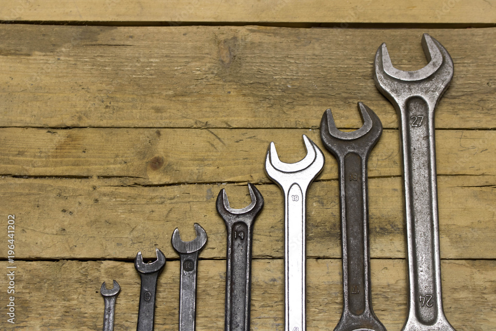 Set of wrenches on a wooden workbench - obrazy, fototapety, plakaty 