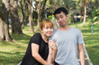 © tirachard - Young Asian love couple relax after an excercise in the park by playing to each other with emotion of love in warm afternoon. Young couple give a sense of love in the park. Couple outdoor excercise.