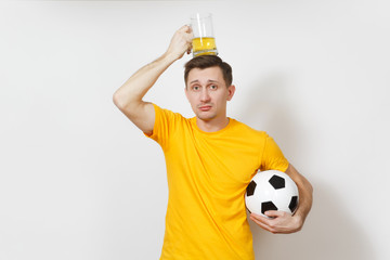 Wall Mural - Inspired young fun upset European man, fan or player in yellow uniform hold on head pint mug of beer, soccer ball cheer favorite football team isolated on white background. Sport, lifestyle concept.