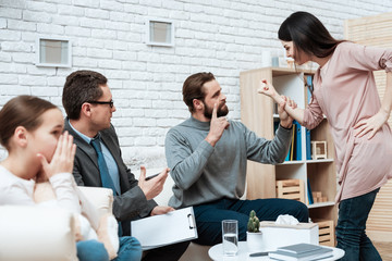 Wall Mural - Confident adult man tries to calm aggressive young woman at reception with family psychologist.