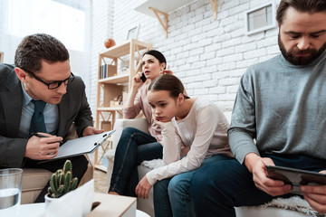 Wall Mural - Little girl with parents makes helpless gesture at psychologist's reception.