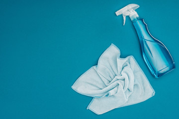 top view of blue rag and spray bottle isolated on blue