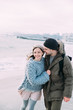 © LIGHTFIELD STUDIOS - young happy couple hugging and walking on winter seashore