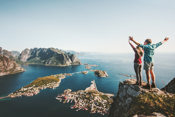 Wall Mural - Happy Couple love and travel raised hands on cliff in Norway man and woman family travelers lifestyle concept summer vacations outdoor Lofoten islands