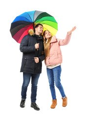 Wall Mural - Young romantic couple with colorful umbrella on white background