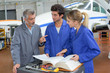 © auremar - People looking at book in aircraft hangar