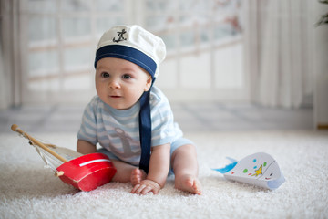 Wall Mural - Little baby boy, playing wtih little boat and little fish at home