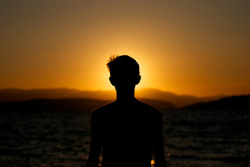 Fascination of silhouette of young boy on sunset