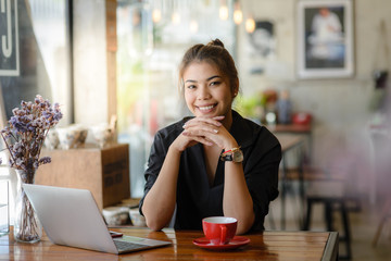 Smiling Asian woman working at cafeteria, lifestyle concept.