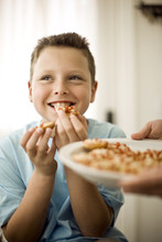 Boy Eating Food Given To Him On Plate