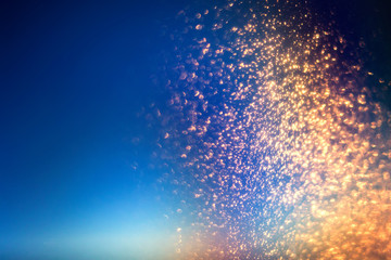 Wall Mural - glitter lights abstract background with gold particles. defocused bokeh dark festive texture.