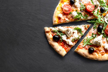 Pizza with tomatoes, meat, mozzarella cheese, black olives and herbs. 