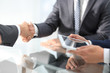 © ASDF - Two confident businessmen shaking hands during a meeting in the
