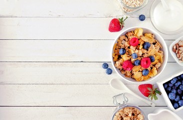 Wall Mural - Cereal and ingredients for a healthy breakfast forming a side border over a white wood background. Top view. Copy space.