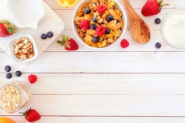 Wall Mural - ingredients for a healthy breakfast forming a corner border over a white wood background. top view. 