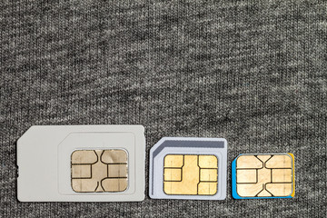 Set of mini, micro and nano simcard. Isolated on grey cloth texture background