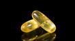 Pills of fish oil on a black background