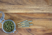 Weed In Jar With Cone Joints On Wood Surface