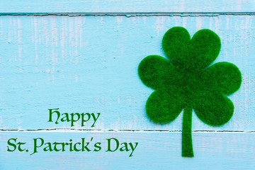 Wall Mural - Happy St Patricks Day message and a lot of green paper clover leaf on Pastel white and blue wooden table background texture.