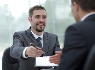 closeup.smiling businessman signing a lucrative contract.the business concept.