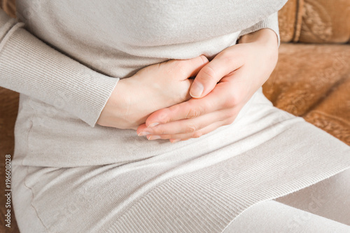 Fényképezés Woman's hand touching her belly because she suffering from abdominal pain at home in the bed