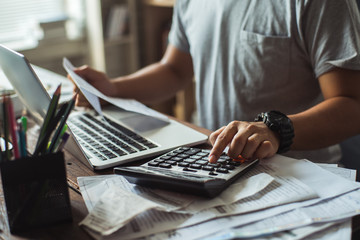 men is calculating the cost of the bill. she is pressing the calculator.