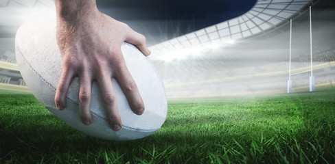 Poster - Composite image of rugby player posing feet on the ball