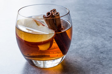 Apple Cider Whiskey Cocktail with Cinnamon Sticks, Ice and Apple Slices.