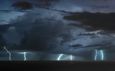 Wall Mural - lightning bolts reflection over the sea. taken during a thunderstorm over the ocean with clouds in the background