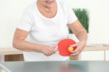 Wall Mural - Senior woman playing table tennis indoors