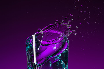 Wall Mural - The water splashing in glass on lilac background