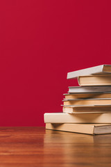 Wall Mural - Cropped view of stack of different books on red