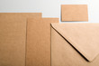 © Freestocker - Top view of cards, envelope and business card in brown on gray background. Mockup.