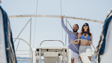 Couple Enjoying Summertime On Sailboat