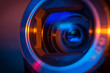 Video camera lens closeup lit by blue and orange neon light
