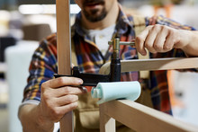 Worker Fixing Clamp On Wooden Frame In Sofa Workshop